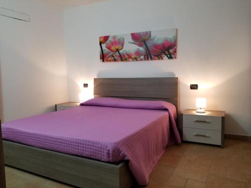 オルビアにあるCasa vacanze mareのベッドルーム1室(紫色のベッド1台、ナイトスタンド2台付)