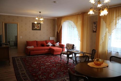 a living room with a red couch and a table at Posthotel in Bad Bertrich