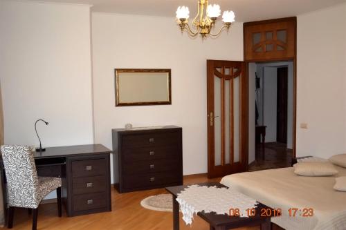 um quarto com uma secretária, uma cama e uma cómoda em Sunny apartment in the city Center em Truskavets