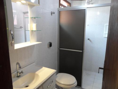 Un baño con ducha, inodoro y lavabo. en Fênix, en Governador Celso Ramos