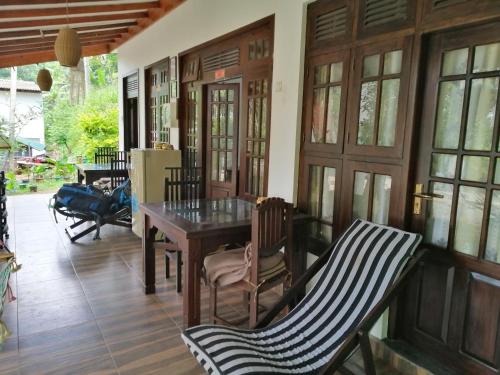 a room with a table and chairs on a porch at Villa Eden Paradise in Ella