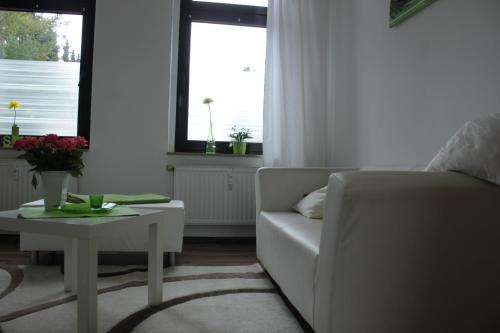 a living room with a white couch and a table at FeWo Kerstin Rossbacher in Solingen