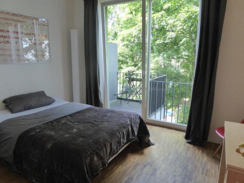a bedroom with a bed and a large window at Apartments Am Friedrichshain in Berlin