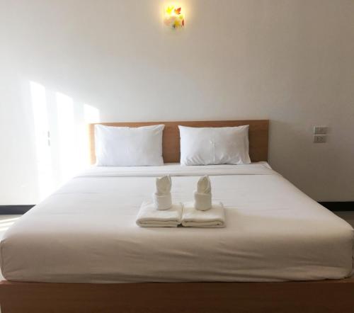 a bed with two towels and two dolls on it at BanKhun in Nakhon Ratchasima