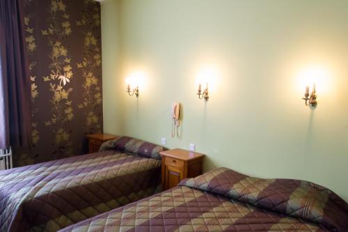 a room with two beds and lights on the wall at La Tete Noire in Montrichard