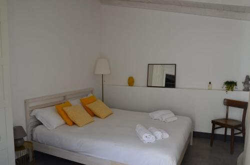 Un dormitorio con una cama blanca con toallas. en Il nido di Ale, en San Gregorio di Catania