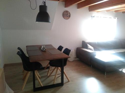 einen Tisch und Stühle im Wohnzimmer mit Sofa in der Unterkunft FeWo LoLa in Rust