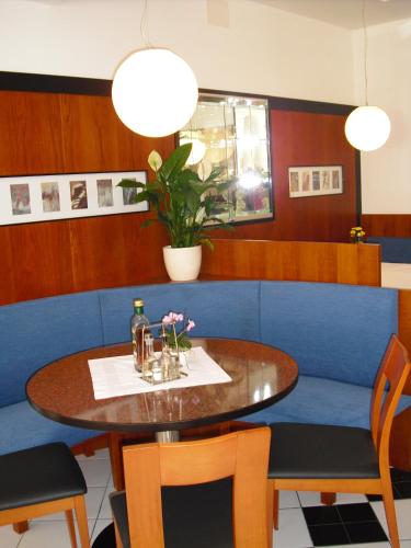 a dining room with a table and a blue couch at Pizzeria Restaurant Wieser in Rasùn di Sotto
