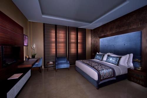 a hotel room with a bed and a television at Souq Waqif Boutique Hotels - Tivoli in Doha