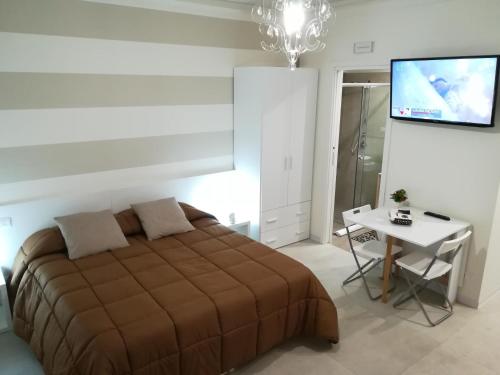 a bedroom with a bed and a table and a television at Guest House B&B Via Marina in Reggio Calabria