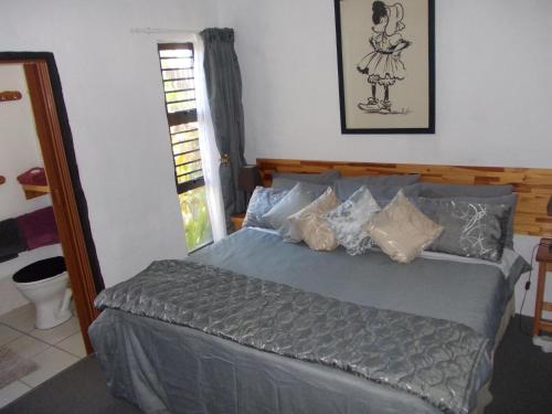 una camera da letto con un letto con un piumone grigio di Villa Ocean Crest B&B a Gansbaai