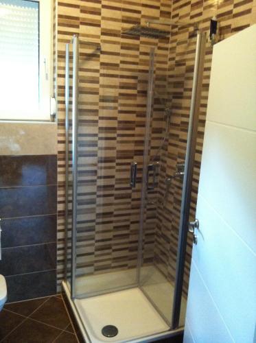 a shower with a glass door in a bathroom at Matanovi Dvori in Slavonski Brod