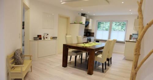 una cucina e una sala da pranzo con tavolo e sedie in legno di Im Corveyer Wäldchen a Traben-Trarbach