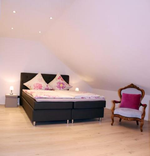 a bedroom with a bed and a chair at Im Corveyer Wäldchen in Traben-Trarbach