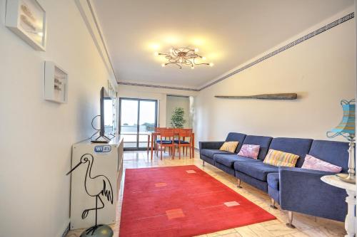a living room with a blue couch and a red rug at In Faro with Sea View in Faro