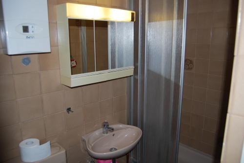 a bathroom with a sink and a mirror and a toilet at 6 Schulstraße in Bieber