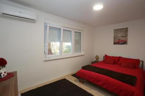 塞拉耶佛的住宿－Seher，一间卧室设有红色的床和窗户。