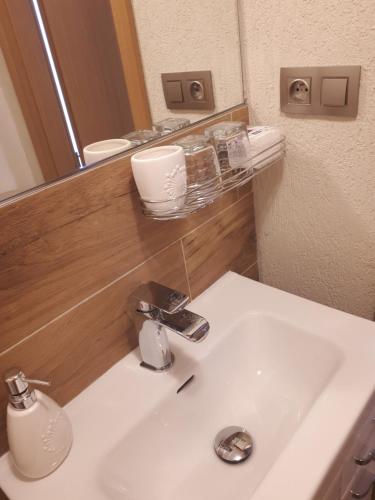 a bathroom with a white sink and a mirror at Apartament TA3 in Veľký Slavkov