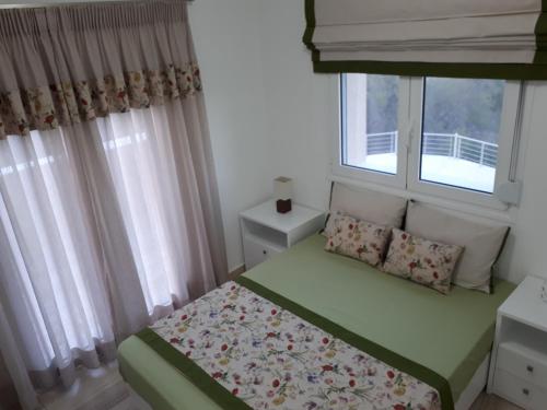a small bedroom with a bed and a window at Villa Irini - Cretan Luxury Villa with Amazing View in Paraspórion