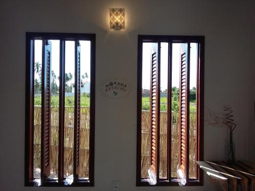 two windows with vertical blinds on a wall at Morada Patacho in Pôrto de Pedras
