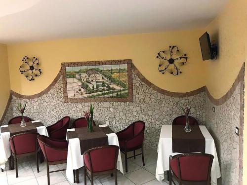 a restaurant with tables and chairs and a mosaic on the wall at Villa Dei Fiori in Montoro Inferiore