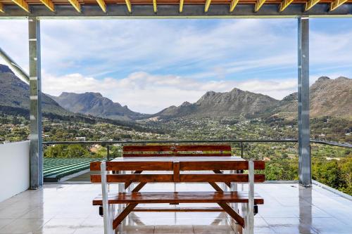 a group of benches sitting on a balcony with mountains at Mount Bay in Hout Bay