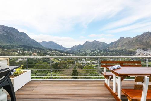 a balcony with a table and a view of mountains at Mount Bay in Hout Bay