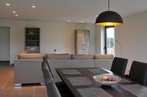 a living room with a table and a couch at Maison la Belle Vue in Mont-de-l'Enclus