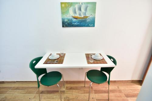 una mesa con dos sillas y un cuadro en la pared en Estalagem 11 Suites, en Arraial do Cabo