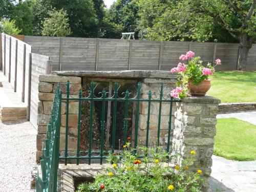 a garden with a gate with flowers on it at Gite Ker Maria Gite Ker Louis Piscine in Saint-Gravé