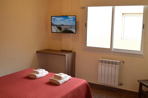 
a bed room with a table and a television at Hotel Luis III in Mar del Plata
