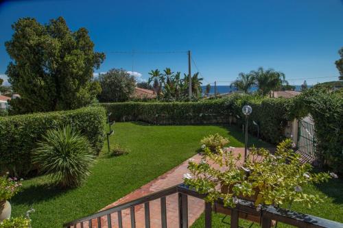 a garden with green grass and plants and a fence at Villa Iaia in Fontane Bianche