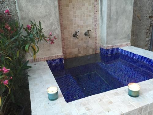 a bathroom with a shower with a blue tiled floor at Cottage du Château "Les Sources d'Arvory" in Valensole