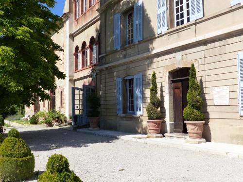 a building with plants in pots in front of it at Cottage du Château "Les Sources d'Arvory" in Valensole