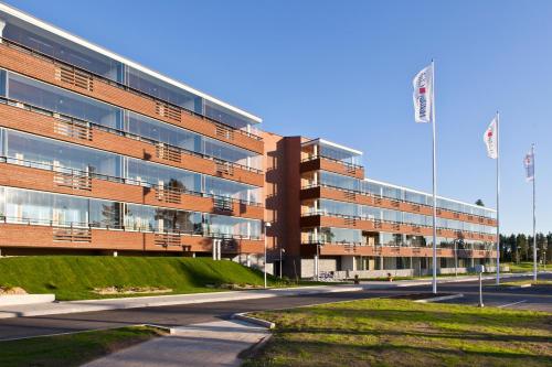 un gran edificio de ladrillo con dos banderas delante en Holiday Club Katinkulta Superior Apartments, en Vuokatti