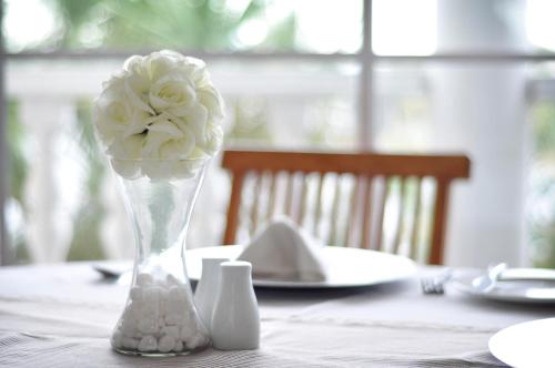 a vase filled with white roses sitting on a table at Bell Rosen Guest House in Bellville