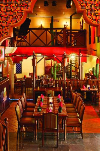 a restaurant with wooden tables and chairs in a room at Millennium Airport Hotel Dubai in Dubai