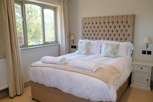 a bedroom with a large bed with white sheets and pillows at Blacknest Golf and Country Club in Alton
