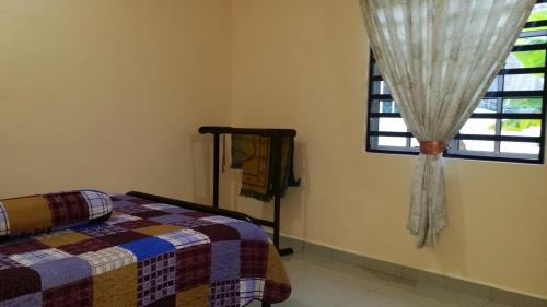 a bedroom with a bed and a window at IsMa Lumut Homestay in Lumut