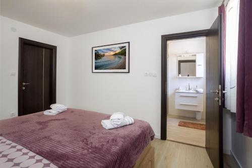 a bedroom with a bed and a bathroom with a sink at Nena in Split