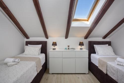 a attic bedroom with two beds and a window at Nena in Split