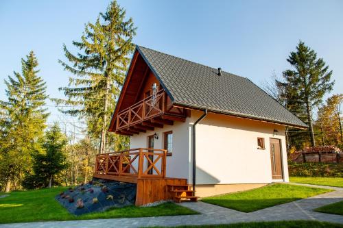 a small house with a porch and a balcony at Domki na Beskidzie 1861 in Istebna