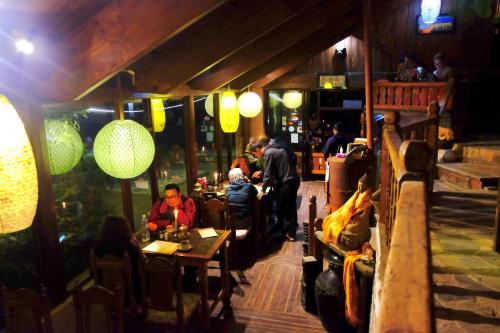 a group of people sitting at tables in a restaurant at Hotel At The End Of The Universe in Nagarkot
