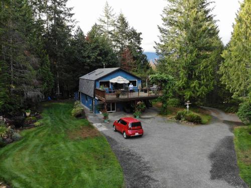 an aerial view of a house with a red van parked in the driveway at Beaver Hut Bed And Breakfast in Port Alberni