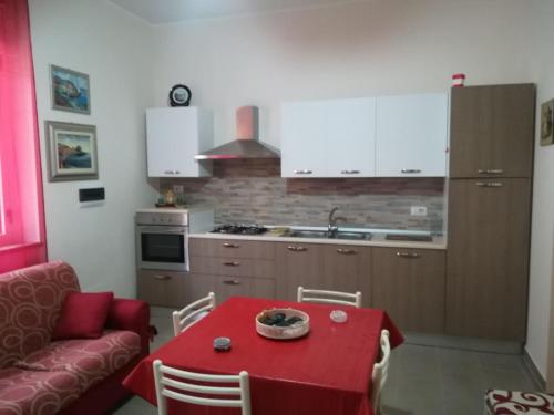 a kitchen with a red table with a red table cloth at Casa vacanze Scilla in Scilla
