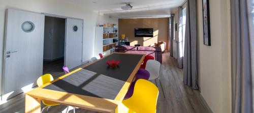 亞眠的住宿－Le 360 TOUR PERRET 19eme PANORAMA 4 ETOILES，一间带桌子和黄色椅子的用餐室