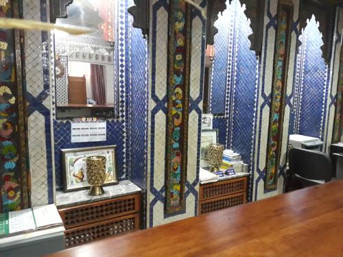 um quarto com paredes azuis com uma mesa e um espelho em Hotel Lixus em Nador