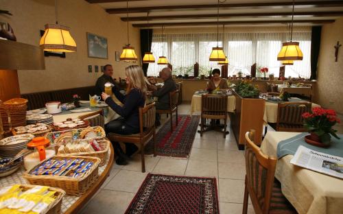 a group of people sitting at tables in a restaurant at Hotel Garni Jägerhof in Sigmaringen