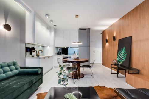 a living room with a green couch and a table at Apartamenty Tespis - Francuska Atal Park in Katowice