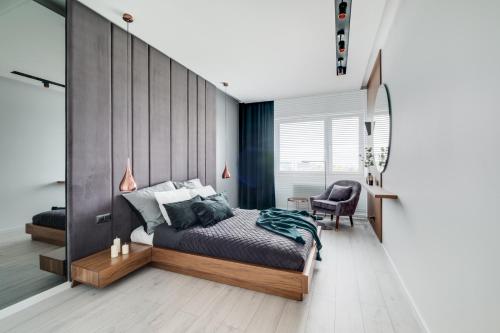 a bedroom with a bed and a desk and a chair at Apartamenty Tespis - Francuska Atal Park in Katowice